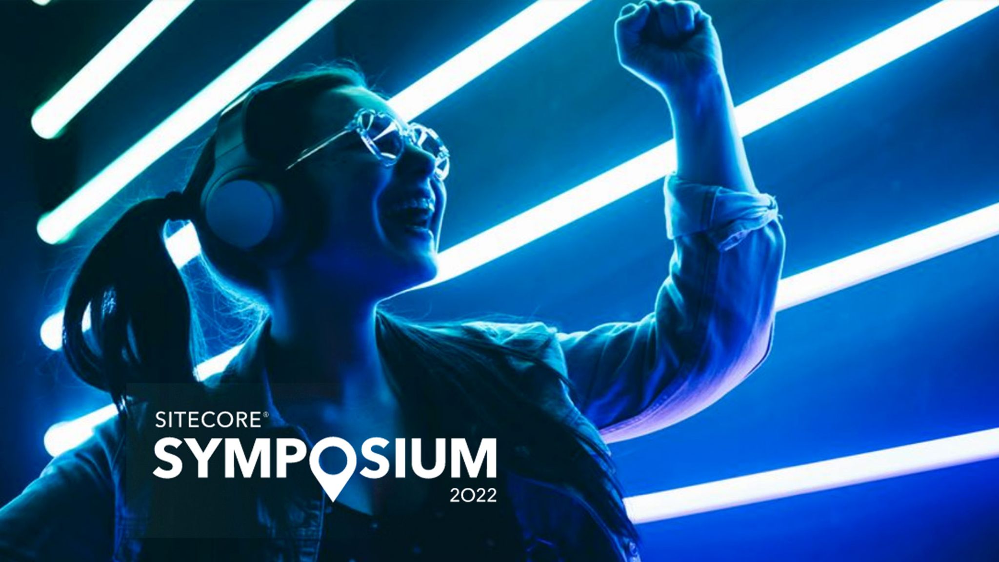 Sitecore Symposium 2022 logo overlaying an image of a young woman holding her arm up in joy against a background of parallel neon lights.