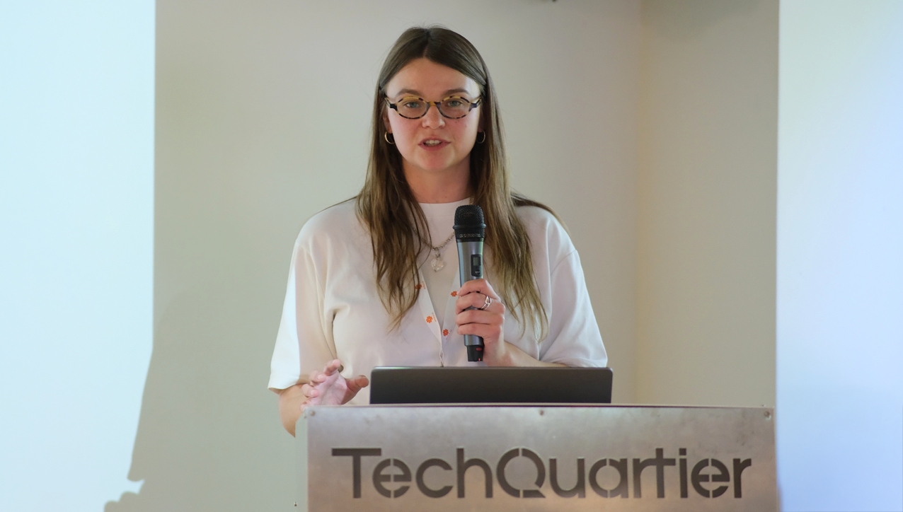A person standing at a podium holding a microphone

AI-generated content may be incorrect.
