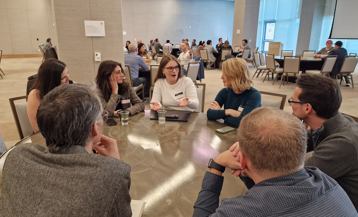 A group of people sitting around a table
AI-generated content may be incorrect.