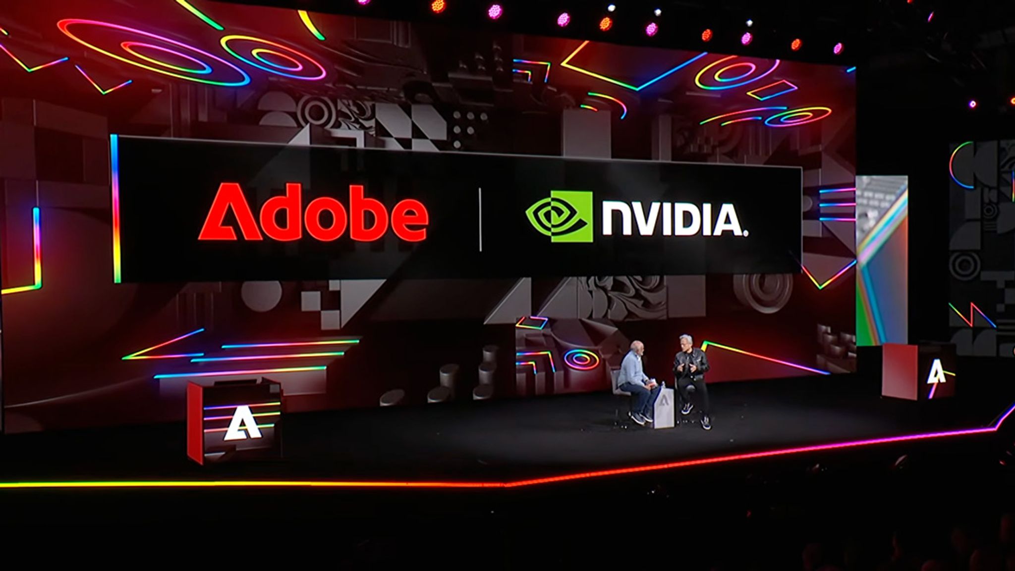 Adobe NVIDIA logos above a stage with CEOs chatting on stage